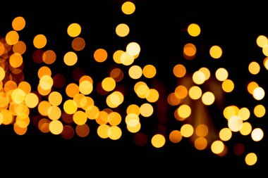 Siyah arka plan üzerine odaklanmamış soyut turuncu bokeh. ufuk ve bulanık çok yuvarlak ışık