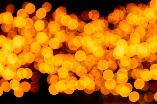 Festive abstract gold background with bokeh defocused and blurred many round yellow light on Christmas dark background — Stock Photo, Image