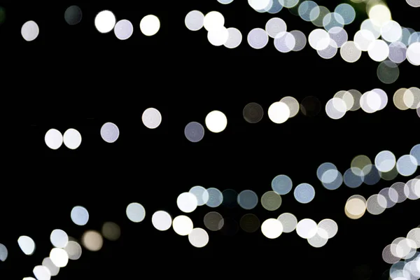 Bokeh astratto di luci bianche della città su sfondo nero. sfocato e sfocato molti luce rotonda — Foto Stock