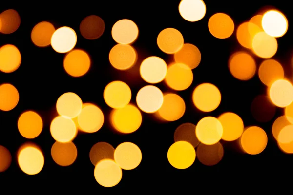 Unfocused abstract gold bokeh on black background. defocused and blurred many round light — Stock Photo, Image