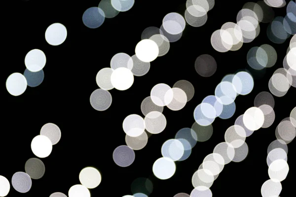 Bokeh astratto di luci bianche della città su sfondo nero. sfocato e sfocato molti luce rotonda — Foto Stock