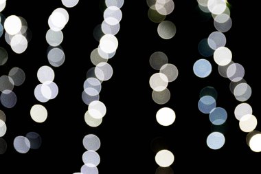 Siyah arka plan üzerine odaklanmamış soyut beyaz bokeh. ufuk ve bulanık çok yuvarlak ışık