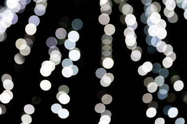 Siyah arka plan üzerine odaklanmamış soyut beyaz bokeh. ufuk ve bulanık çok yuvarlak ışık