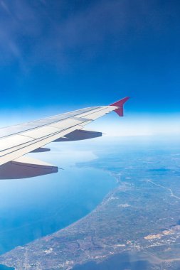 Bulutlarda uçan kanatlar, şehrin arka planında uçan.