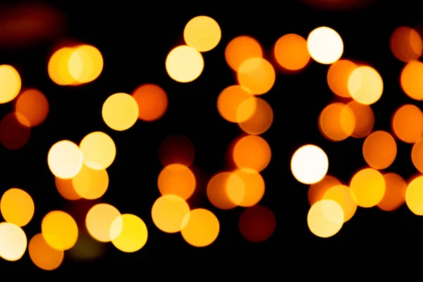 Unfocused abstract yellow bokeh on black background. defocused and blurred many round light — Stock Photo, Image