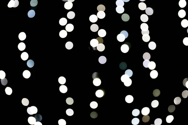 Bokeh abstrato de luzes brancas da cidade sobre fundo preto. desfocado e desfocado muitos luz redonda — Fotografia de Stock