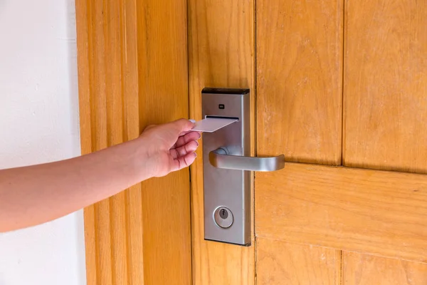 La mano femenina pone y sostiene el interruptor magnético de la tarjeta de llave para abrir la puerta de la habitación del hotel —  Fotos de Stock