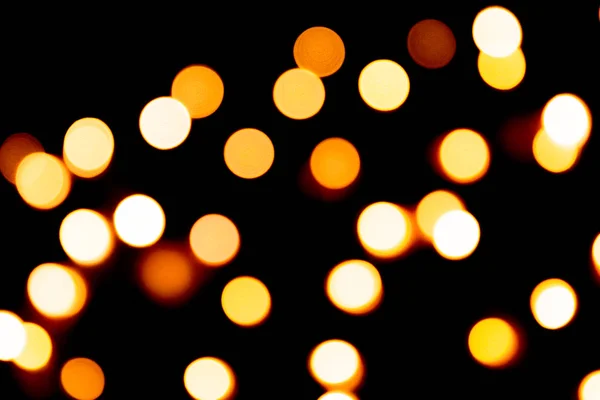 Unfocused abstract gold bokeh on black background. defocused and blurred many round light — Stock Photo, Image