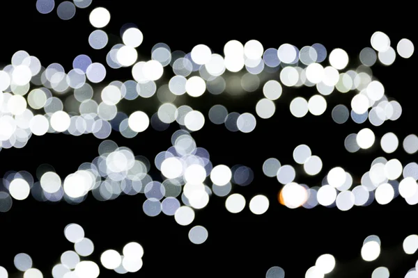 Bokeh branco abstrato sem foco no fundo preto. desfocado e desfocado muitos luz redonda — Fotografia de Stock