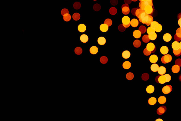 Unfocused abstract gold bokeh on black background. defocused and blurred many round light