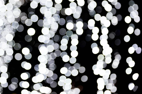 Bokeh abstrato de luzes brancas sobre fundo preto. desfocado e desfocado muitos luz redonda — Fotografia de Stock