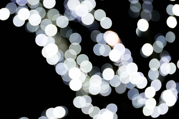 Bokeh astratto di luci bianche della città su sfondo nero. sfocato e sfocato molti luce rotonda — Foto Stock