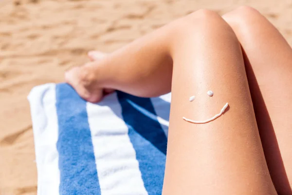 Cara sonriente se dibuja en la pierna femenina bronceada suave sobre el fondo del mar — Foto de Stock