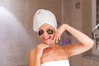 Banyodaki kadın mor göz bandı takıyor. Cilt bakımı ve spa sabah konsepti