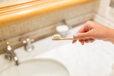 Banyoda diş fırçası üzerinde diş macunu uygulayan çekici kadın el Kırpılmış görüntü. Güzellik sağlıklı yaşam sabah kavramı