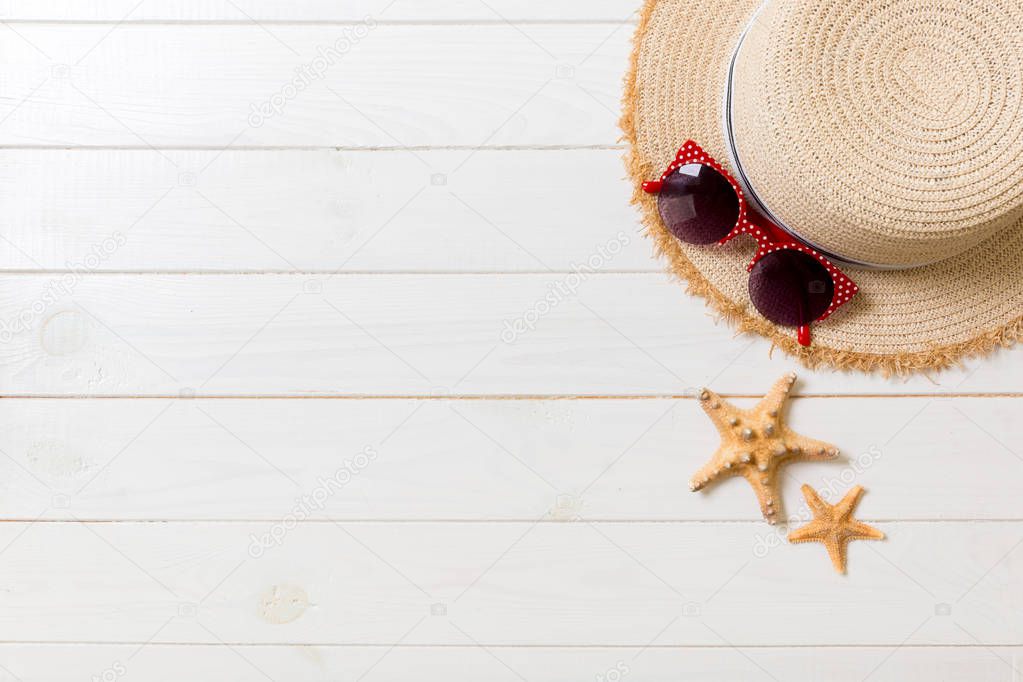 Straw hat, sun glasses and seashells on a white wooden background. top view summer holiday concept with copy space