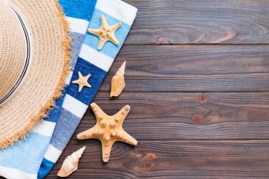 Hasır şapka, mavi havlu ve denizyıldızı beyaz ahşap bir arka plan üzerinde. kopya alanı ile üst görünüm yaz tatili konsepti