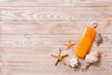 kopya alanı ile ahşap arka plan üzerinde güneş koruma krem şişe ve deniz kabukları. yaz seyahat tatil düz yatıyordu kavramı