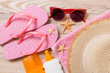 parmak arası terlik, hasır şapka, denizyıldızı, güneş kremi şişesi, ahşap arka plan üst görünümünde vücut losyon sprey . düz yatıyordu yaz plaj deniz aksesuarları arka plan, seyahat konsepti