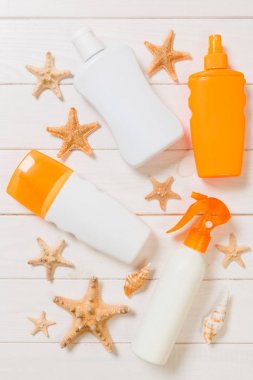 düz yatıyordu konsept yaz seyahat tatil. Kopya alanı ile beyaz ahşap masa üzerinde denizyıldızı ile güneş kremi şişeleri