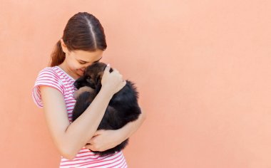Genç kadın bir küçük şirin köpek yavrusu sarılma sahiptir