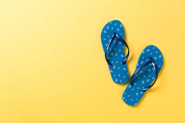 Blaue Flip Flops auf gelbem Hintergrund. Ansicht von oben mit Kopierraum — Stockfoto