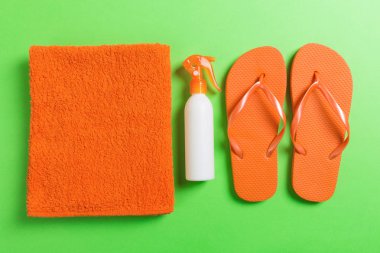 Beach düz döşeme aksesuarları üst görünümü. deniz kabukları, denizyıldızı, havlu ve flip-flop renkli arka plan kopya alanı ile güneş kremi şişe