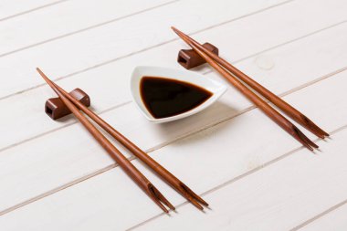 Beyaz ahşap masa arka plan üzerinde çubukları ile Soya sosu