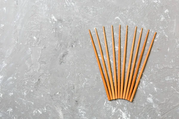 Siyah çimento taş arka plan üzerinde birçok bambu çubukları, kopya alanı ile üst görünümü. bir süs şeklinde suşi çubukları bir sürü