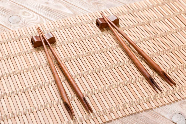Два набора суши палочки для еды на деревянном бамбуковом фоне, вид сверху — стоковое фото