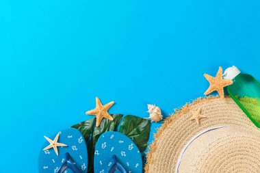Kopya alanı ile mavi arka plan üst görünümünde hasır şapka ve deniz kabukları ile Plaj aksesuarları