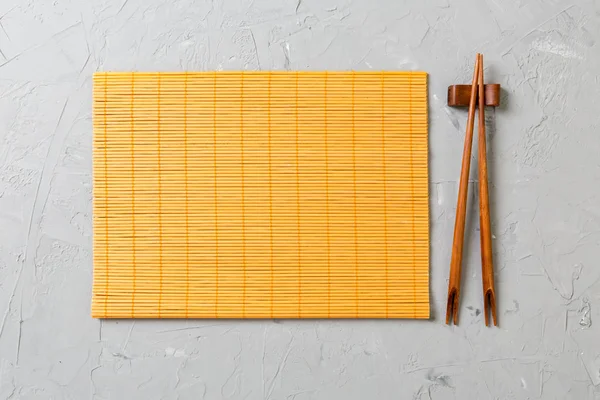 kopya stace ile taş Arka Plan Üst görünümü üzerinde boş bambu paspas veya ahşap plaka ile iki suşi çubukları