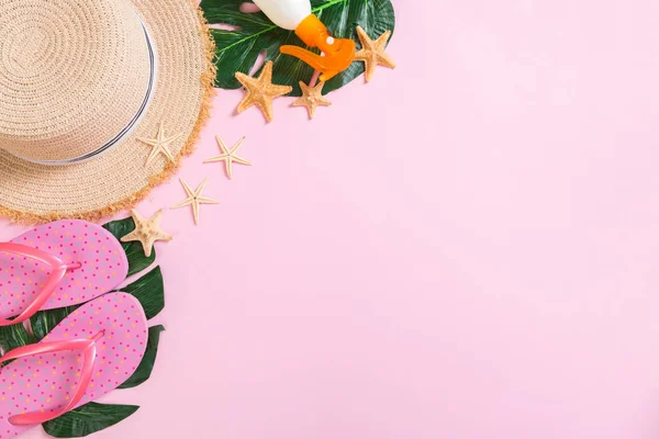 Accesorios de playa con sombrero de paja, botella de protector solar y costero sobre fondo rosa vista superior con espacio para copiar — Foto de Stock