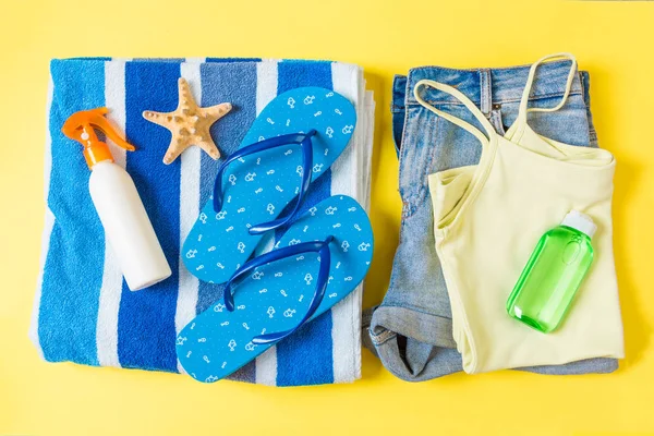 Composition à plat avec accessoires de plage bleu sur fond de couleur jaune. Fond des vacances d'été. Articles de voyage et de vacances vue du dessus — Photo