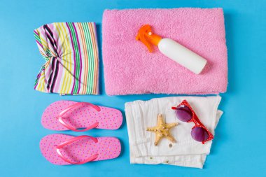 Mavi renk arka plan üzerinde Plaj aksesuarları ile Düz yatıyordu kompozisyon. Yaz tatili geçmişi. Tatil ve seyahat öğeleri üst görünüm