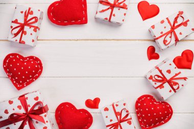 Sevgililer veya diğer tatil el yapımı mevcut kağıt ile tatil sarmalayıcı kırmızı kalpler ve hediye kutusunda. Tasarım için kopya alanı görünümüyle Beyaz ahşap masa üstü, boş alanı kutusu hediye sunmak