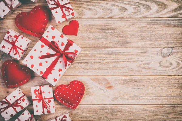 발렌타인 데이 또는 다른 휴일 수 제 종이에으로 현재 휴가 래퍼에 빨간 하트와 선물 상자. 디자인을 위한 오렌지 나무 테이블 복사 공간 평면도, 빈 공간에 선물 상자를 제시 — 스톡 사진