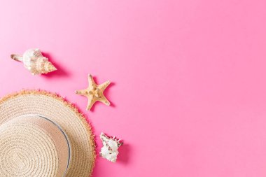 Pembe ahşap masa üzerinde deniz kabukları ile Plaj şapkası. kopya alanı üst görünümü ile yaz arka plan kavramı
