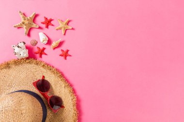 Kopya alanı ile pembe arka plan üst görünümünde hasır şapka ve deniz kabukları ile Yaz tatili arka plan