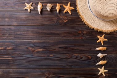 Kahverengi ahşap masa üzerinde deniz kabukları ile Plaj şapkası. kopya alanı üst görünümü ile yaz arka plan kavramı