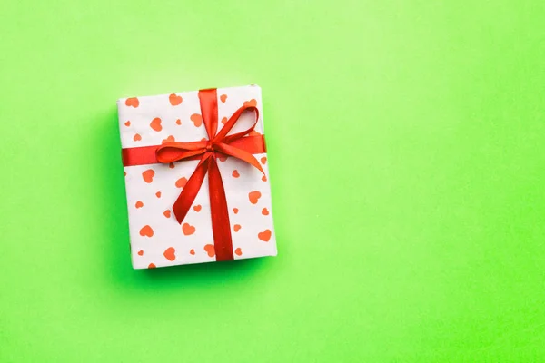 Caixa de presente com fita vermelha e coração no fundo verde, vista superior com espaço de cópia para texto — Fotografia de Stock
