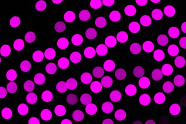 Siyah arka plan üzerinde odaklanmamış soyut mor bokeh. deffocused ve bulanık birçok yuvarlak ışık