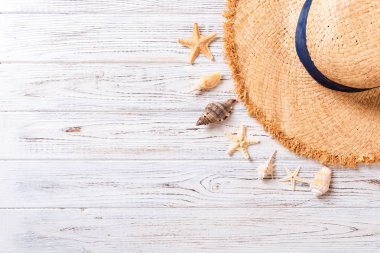 Kahverengi ahşap masa üzerinde deniz kabukları ile Plaj şapkası. kopya alanı üst görünümü ile yaz arka plan kavramı