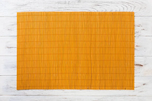Töm asiatisk mat bakgrund. Gul bambu matta på trä bakgrund uppifrån med kopiera utrymme platt Lay — Stockfoto