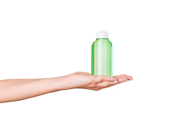 Female hand holding cream bottle of lotion isolated. Girl give tube cosmetic products on white background — Stock Photo, Image
