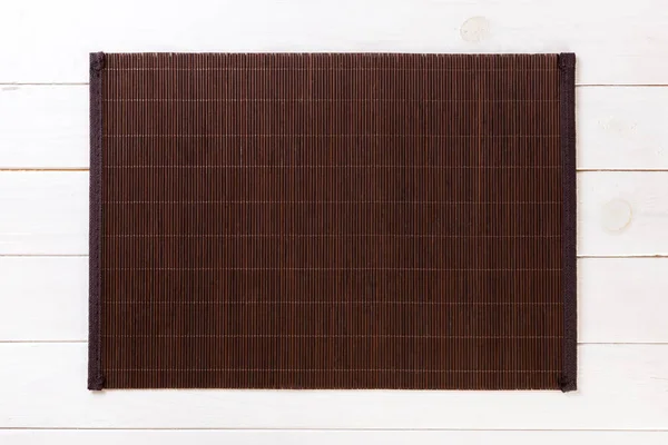Töm asiatisk mat bakgrund. Mörk bambu matta på vit trä bakgrund uppifrån med kopia utrymme platt Lay — Stockfoto