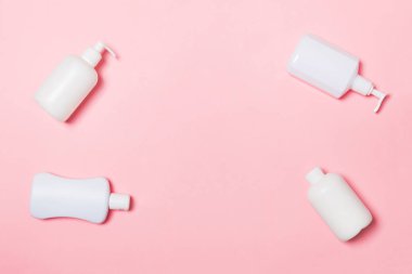 Beyaz Kozmetik kapları seti pembe arka plan üzerinde izole, kopya alanı ile üst görünümü. Tasarım için boş alana sahip plastik vücut bakım şişe kapları Grubu