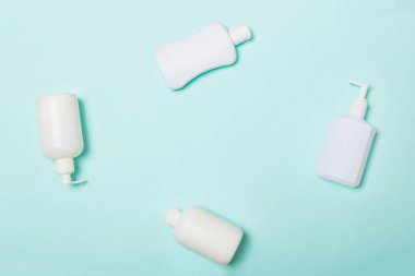 Beyaz Kozmetik kapları mavi arka plan üzerinde izole seti, kopya alanı ile üst görünümü. Tasarım için boş alana sahip plastik vücut bakım şişe kapları Grubu