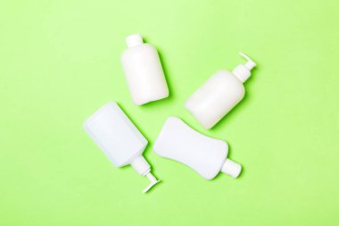 Beyaz Kozmetik kapları yeşil arka plan üzerinde izole seti, kopya alanı ile üst görünümü. Tasarım için boş alana sahip plastik vücut bakım şişe kapları Grubu