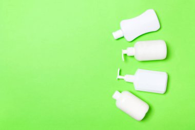 Beyaz Kozmetik kapları yeşil arka plan üzerinde izole seti, kopya alanı ile üst görünümü. Tasarım için boş alana sahip plastik vücut bakım şişe kapları Grubu